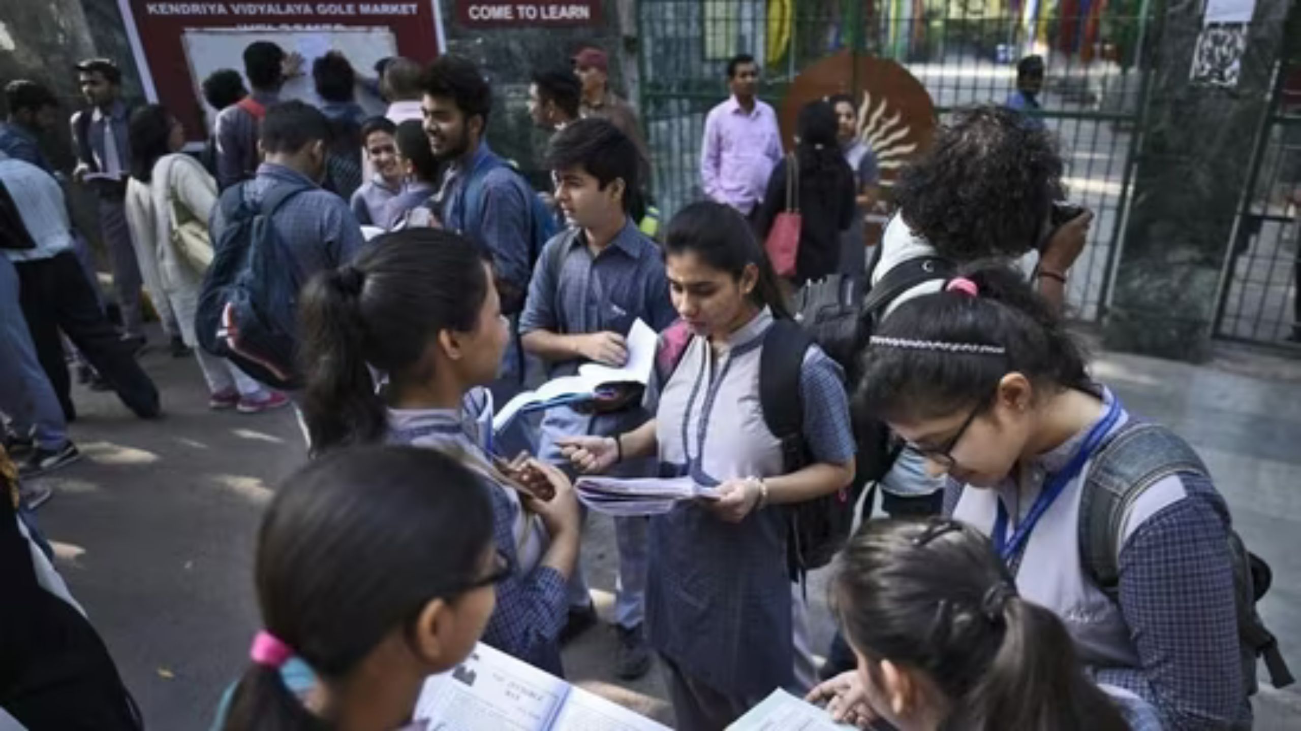 Students reading books outside exam hall